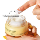 Crème visage hydratante COSRX showing a light non-greasy texture in a jar with a finger applying the cream.