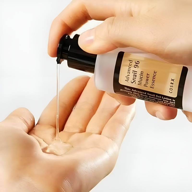 Essence Advanced Snail 96 COSRX serum visage anti age being poured into hand, highlighting moisturizing properties.